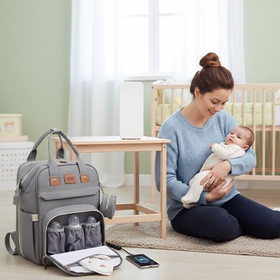 Sac a langer gris une maman tient son bebe dans ses bras